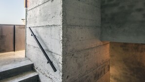 A concrete staircase with metal handrails, leading to a higher level. - Kook Hotel Tarifa (Tarifa)