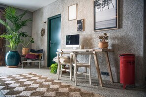 A cozy room with a desk, chair, and potted plants.