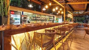 Un espace bar avec des meubles en bois et un réfrigérateur Coca-Cola.