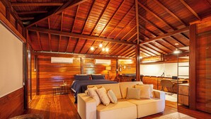 Une pièce spacieuse avec un plafond en bois, un canapé, un lit, un bureau et une chaise.