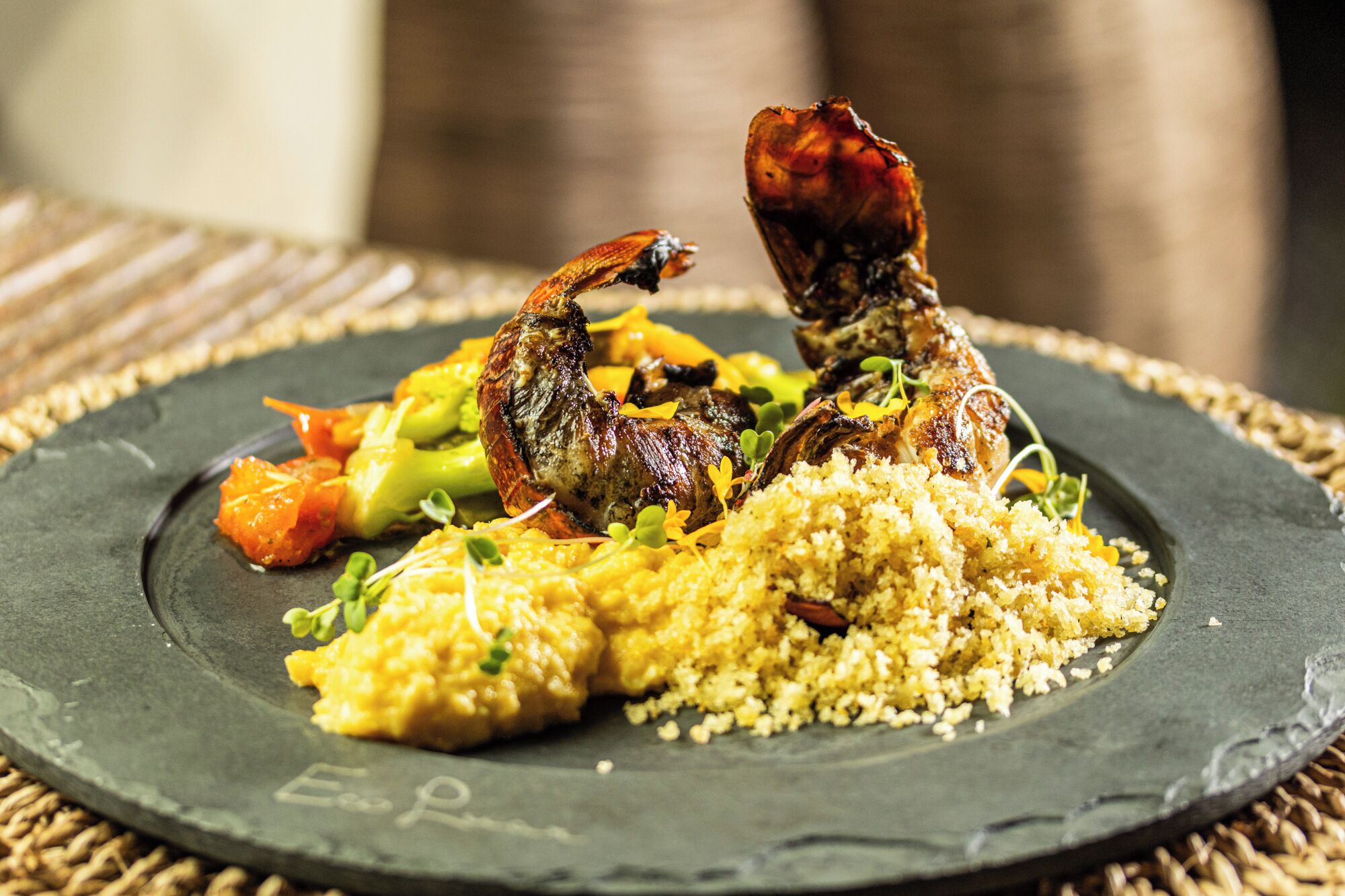 A plate of food with grilled chicken, couscous, and vegetables.