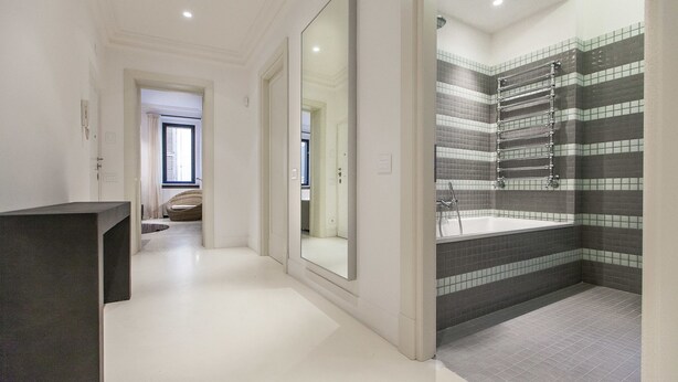 Une salle de bain moderne avec un grand miroir, une baignoire et un espace douche.