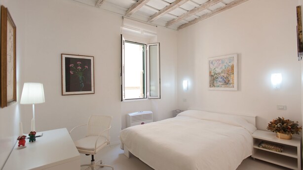 Ein Schlafzimmer mit Bett, Stuhl, Schreibtisch und Fenster.
