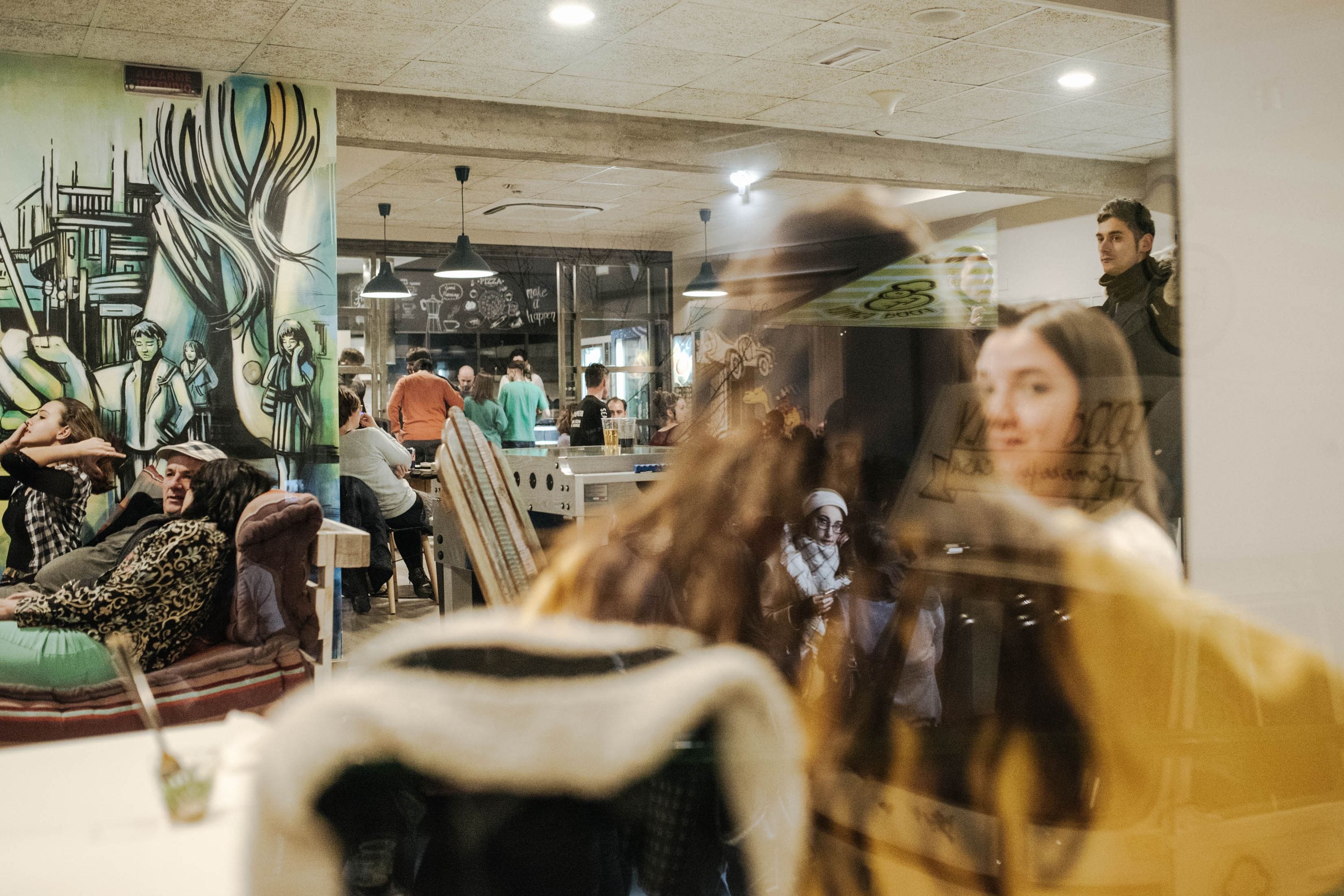 A restaurant interior with a mural, seating, and a counter.