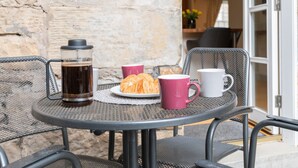 A round metal table with a glass coffee pot, two croissants, and two mugs. - 138 North Street (St. Andrews)