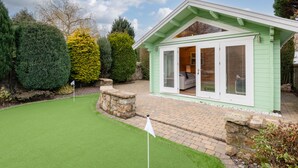 A green building with a patio area, a small lawn, and various trees. - 138 North Street (St. Andrews)