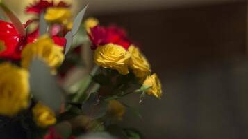 Um buquê de flores amarelas e vermelhas num vaso.