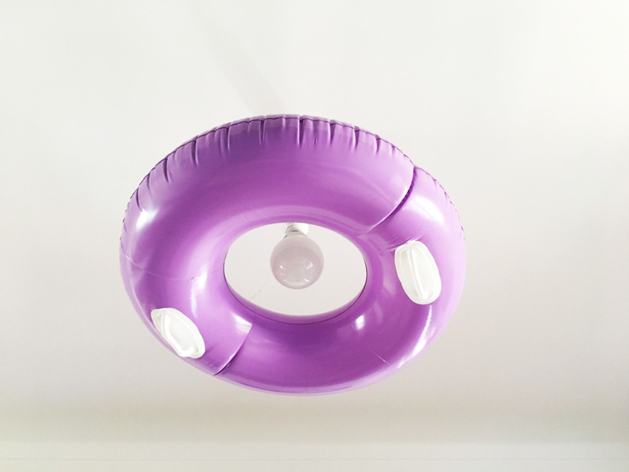 Un flotador morado con forma de aro y una bombilla en el centro.