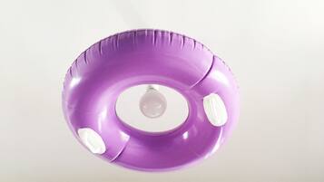 Un flotador morado con forma de aro y una bombilla en el centro.