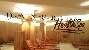 A spa with wooden loungers arranged in rows, a ceiling with recessed lighting, and a sign reading "Danubius HealthSpa". - Ensana Bradet (Sovata)