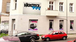 A building with a large sign reading "Hostel 1994" and a smaller sign for "Hostel 1995".