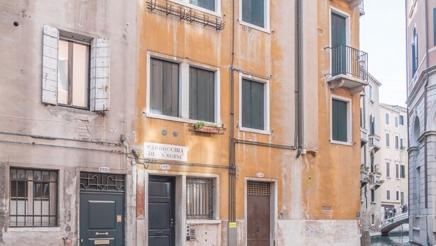 Una calle estrecha con un edificio que muestra la inscripción "Parrocchia di S. Moise".