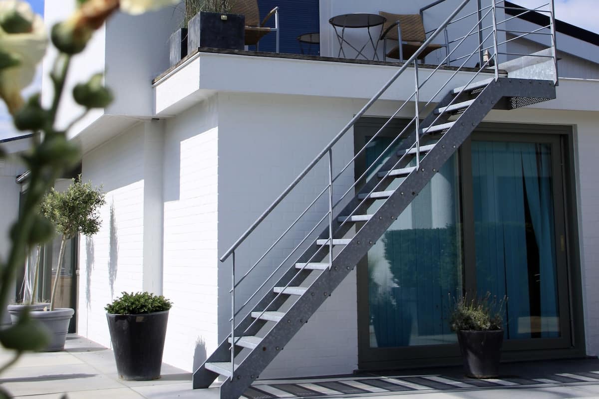 A modern two-story building with a staircase leading to a balcony.