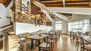 Un ristorante con arredi in legno e un soffitto alto con travi a vista.