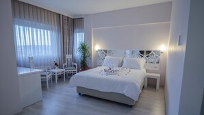 Une chambre d’hôtel moderne, dotée d’un grand lit, d’un bureau et d’une chaise.