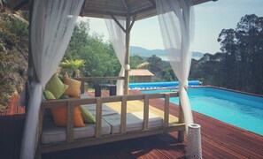 Una piscina al aire libre de temporada, sombrillas, tumbonas