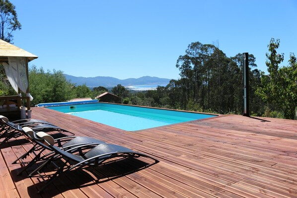 Una piscina al aire libre de temporada, sombrillas