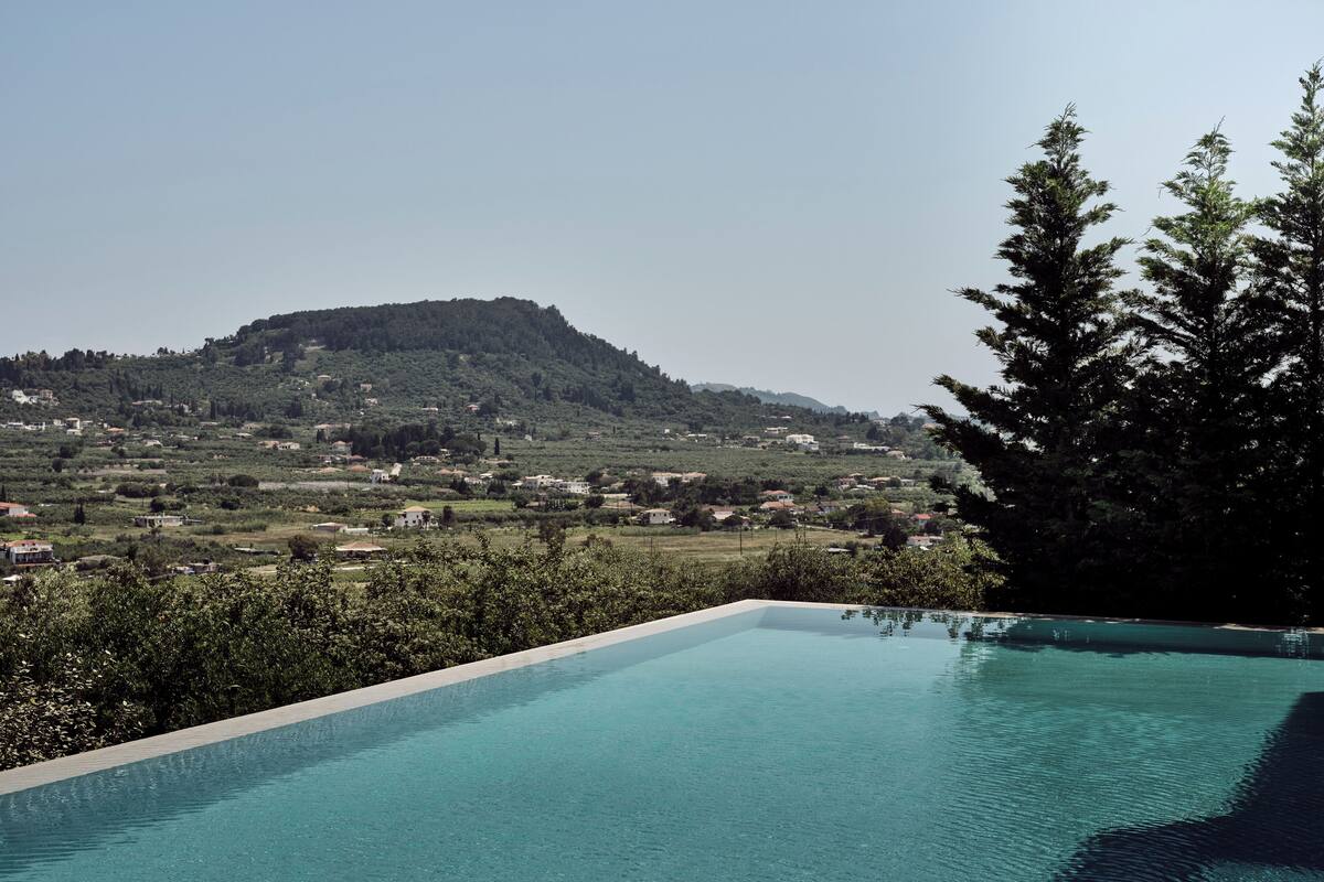 A swimming pool with a view of a mountain and a forest.