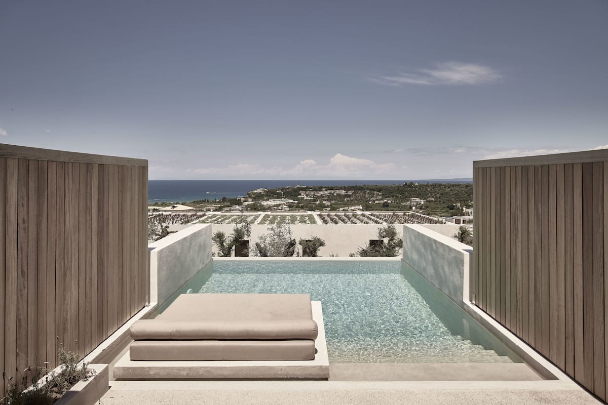 A pool with a view of the sea and buildings.