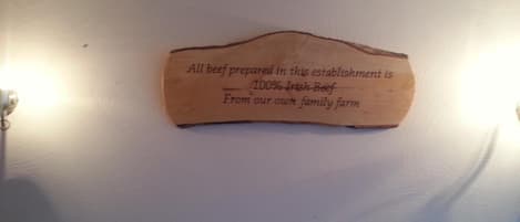 A wooden plaque with text on a white wall.