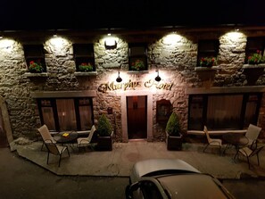 A stone building with a sign reading "Murphy's Hotel". There are outdoor seating areas with chairs and tables.