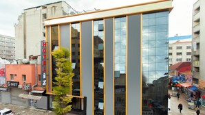 A modern hotel with a reflective glass facade and a vertical strip design. - Hotel Iz (Izmir)