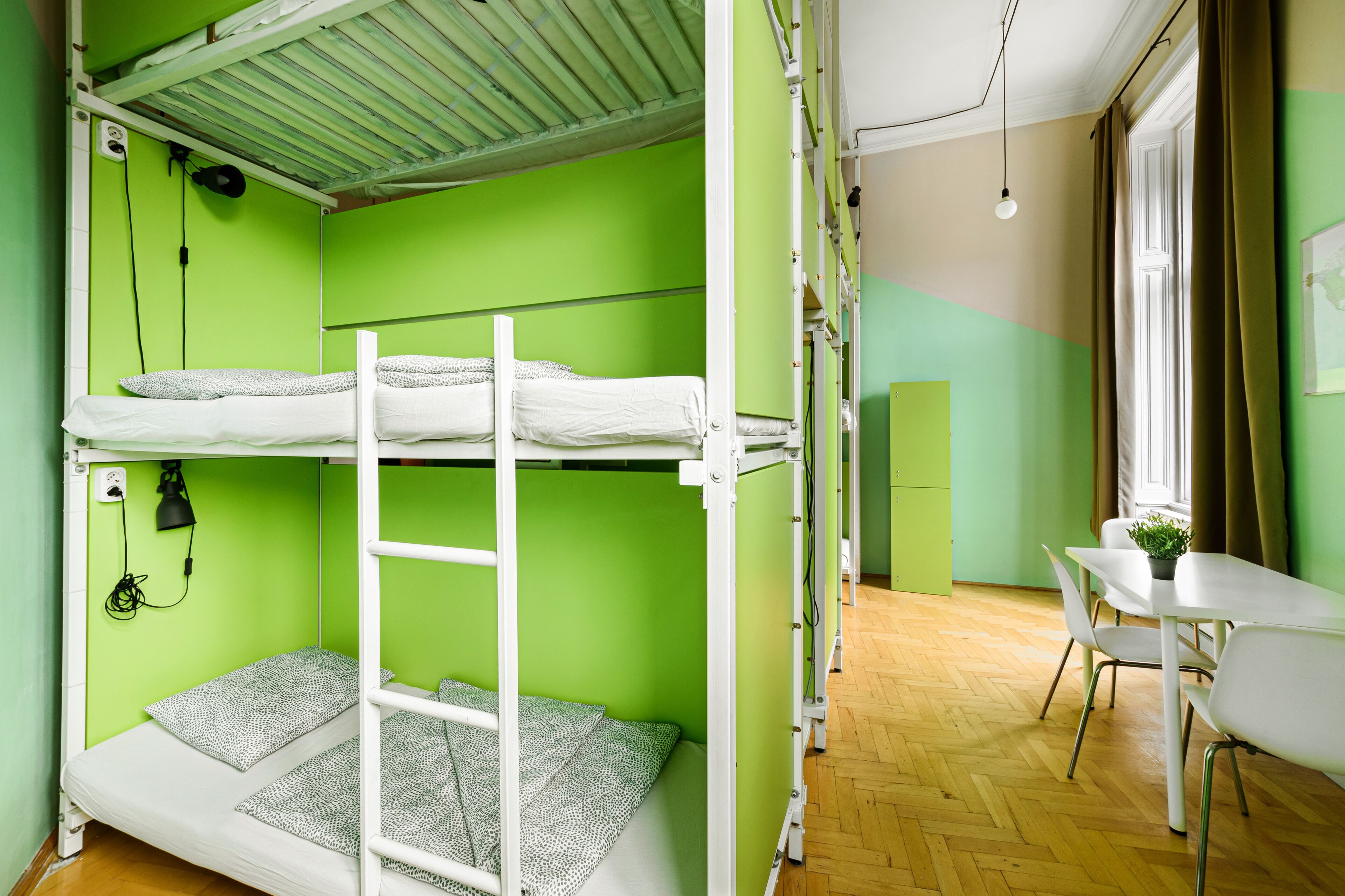 A dormitory room with bunk beds, a desk, and a chair.