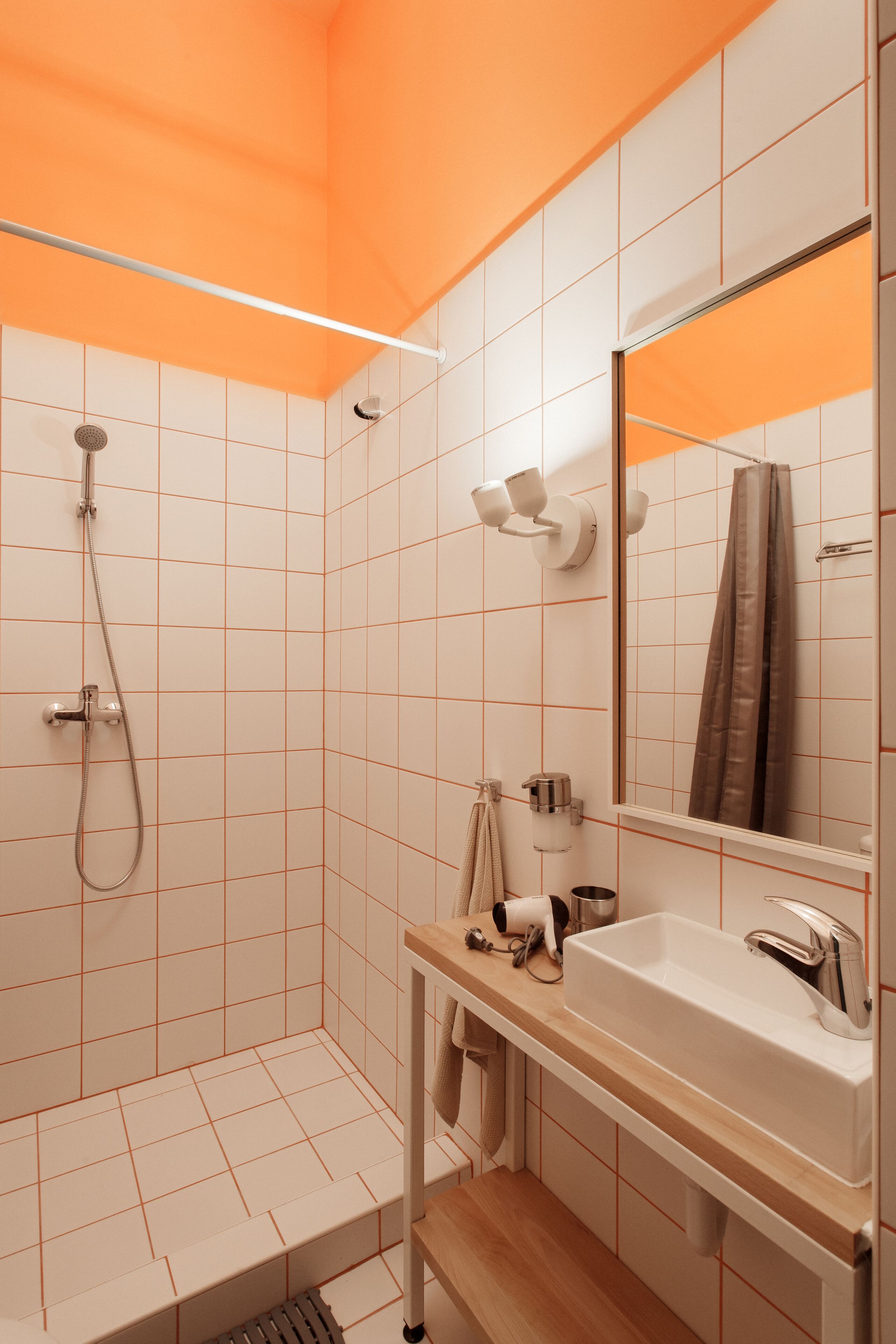 A modern bathroom with a shower, a sink, and a mirror.