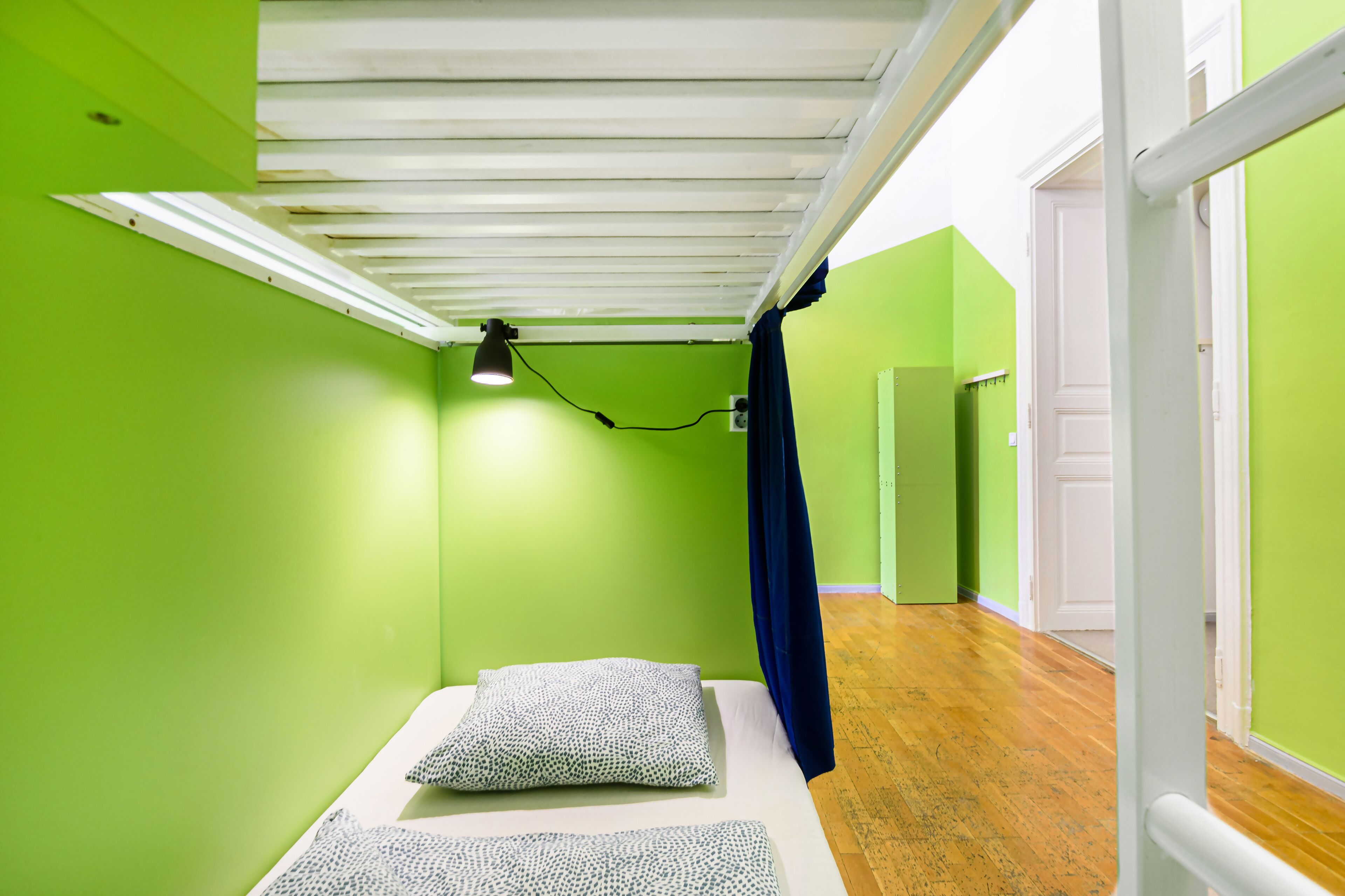 Una stanza con un letto, una lampada a soffitto e una porta.