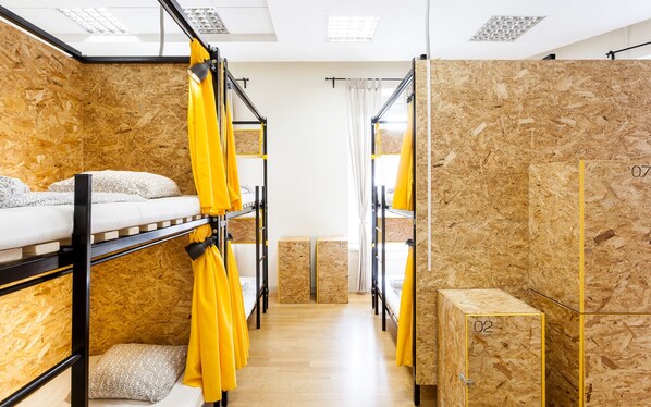 Un dormitorio con literas, paredes de madera y un pequeño banco de madera.