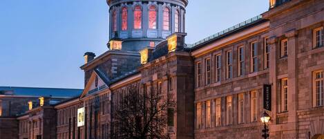 A historic building with a prominent dome and classical architecture, featuring a central courtyard and a café on the ground floor.