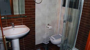 A bathroom with a sink, toilet, and glass shower enclosure.