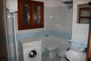 A bathroom with a washing machine, toilet, bidet, and sink. - Rena Majore Resort (Aglientu)