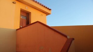 Un edificio con una escalera roja y una puerta.