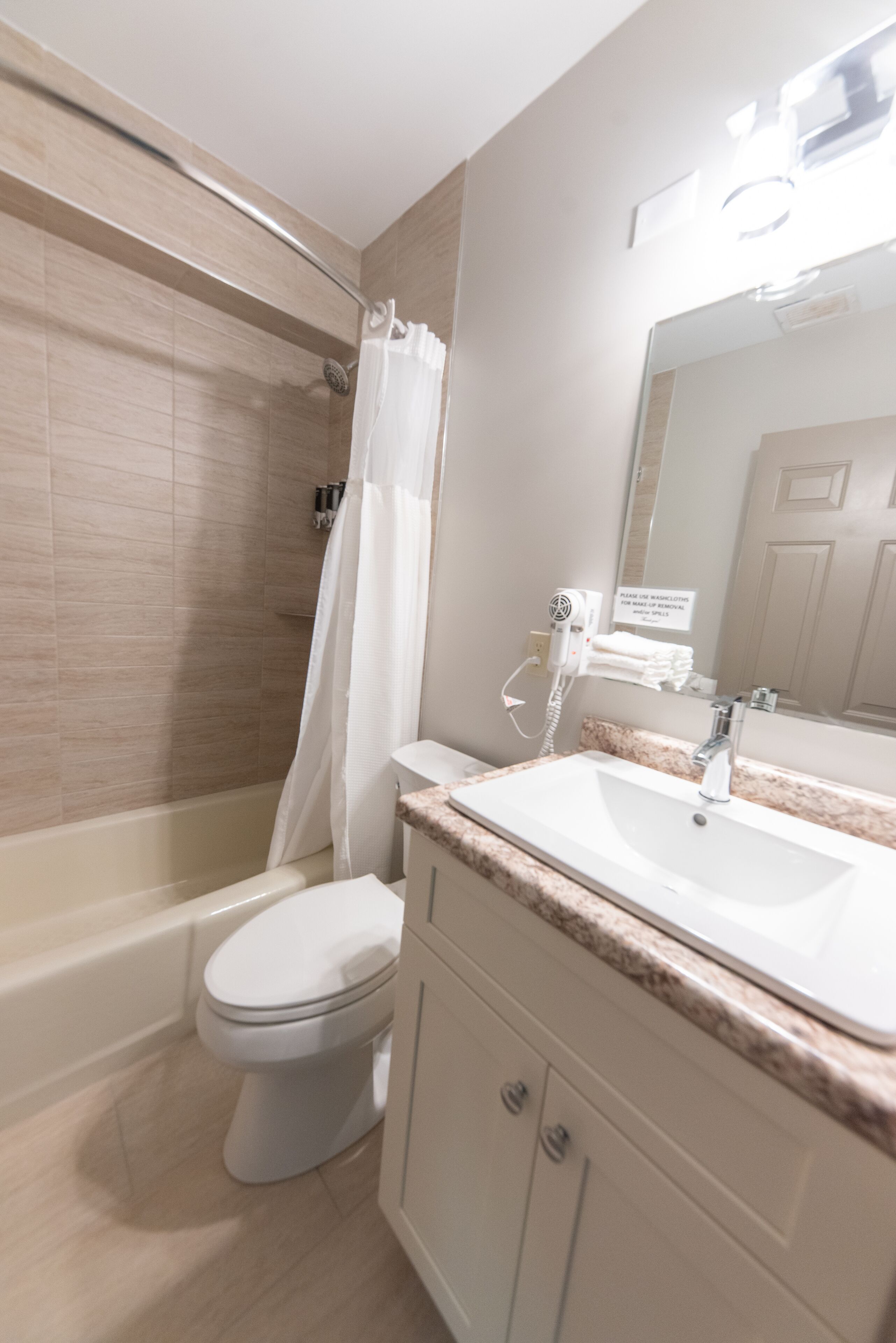 A bathroom with a bathtub, toilet, and sink.