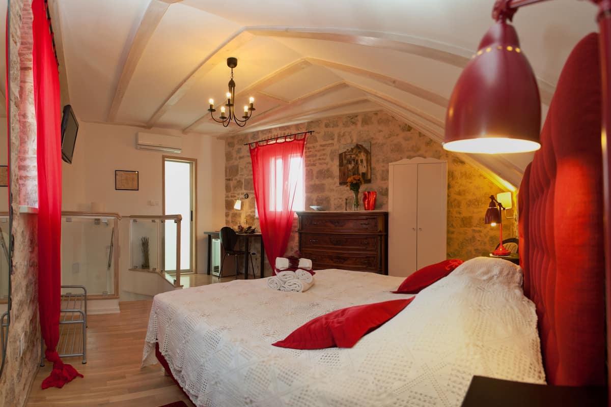 Un dormitorio con una cama grande, un escritorio y un armario.