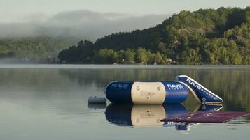 A calm lake with a floating structure labeled "RAVE SPORTS" and a small boat.