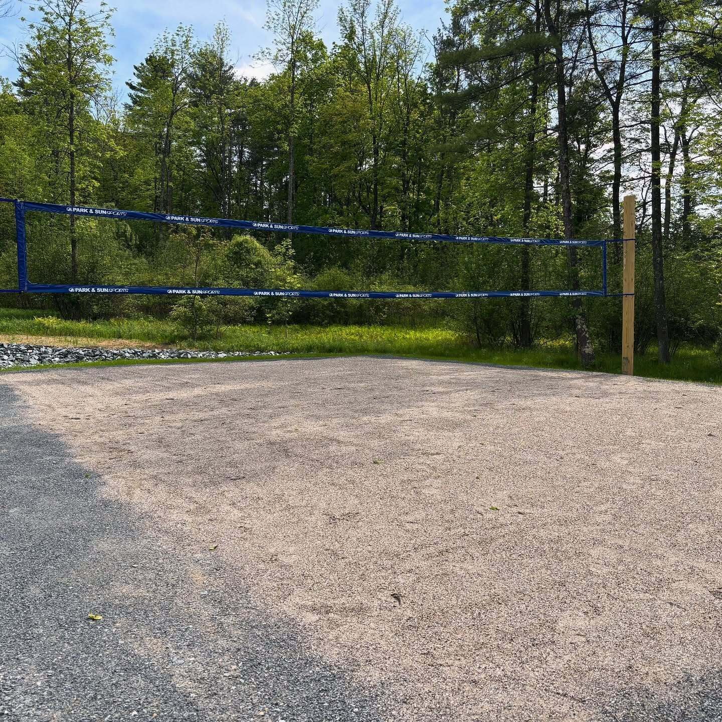 A gravel parking area with a blue barrier tape marked "Park & Sun Sports".