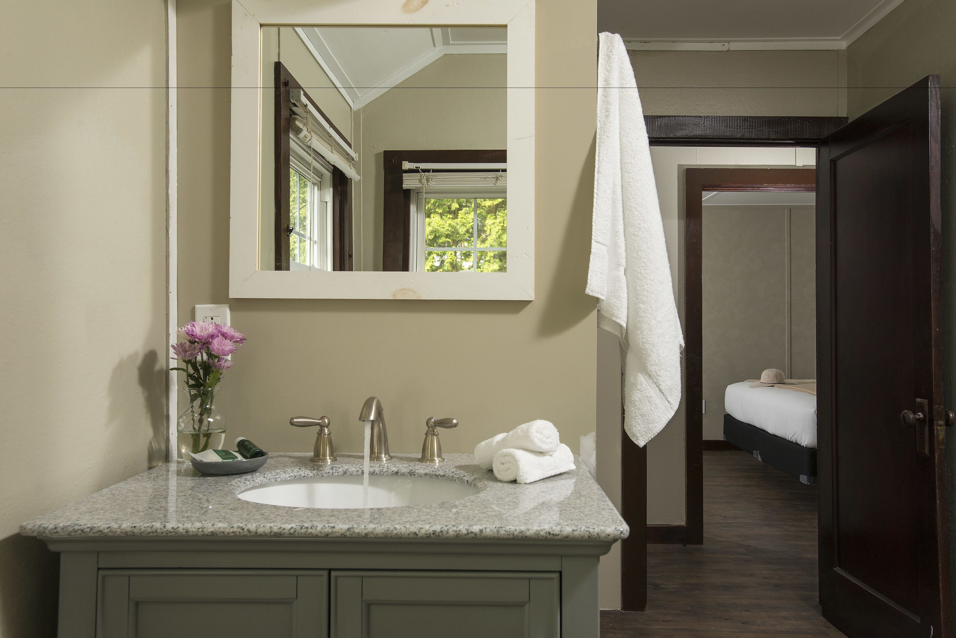 Une salle de bain avec un lavabo, un miroir et un porte-serviettes.