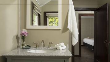 Une salle de bain avec un lavabo, un miroir et un porte-serviettes.