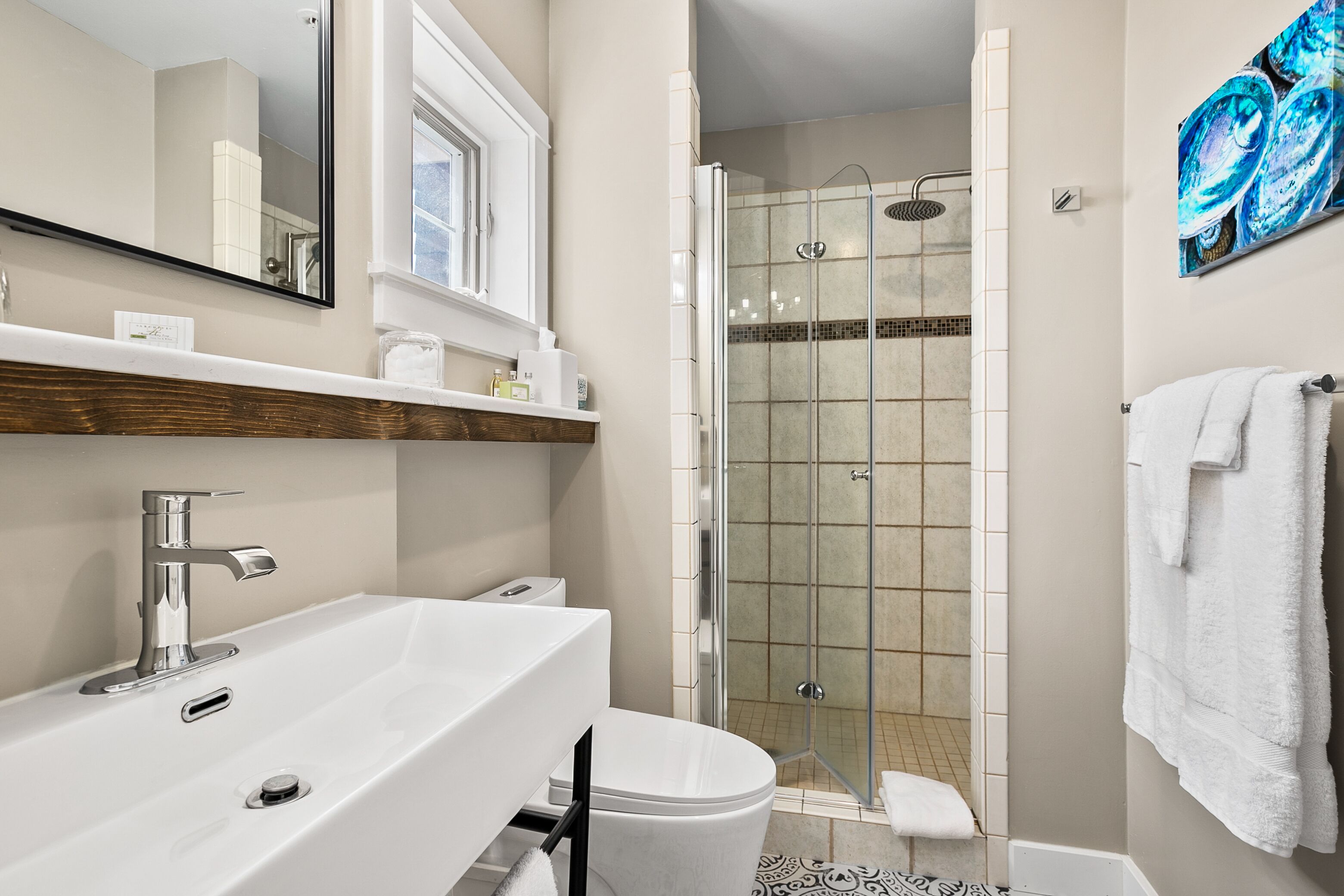 A modern bathroom with a large sink, toilet, and shower.