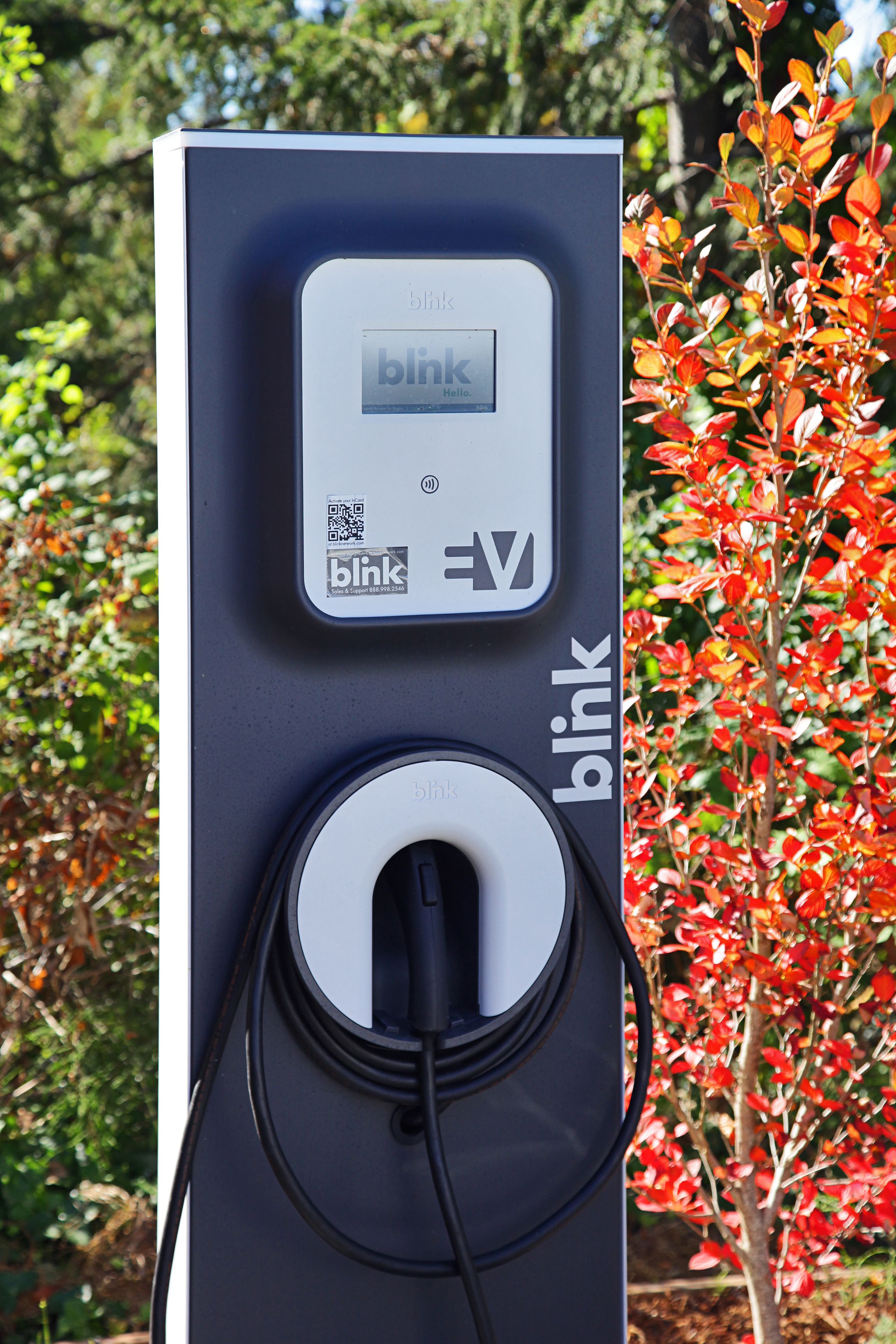 A Blink charging station with a QR code and the Blink logo.