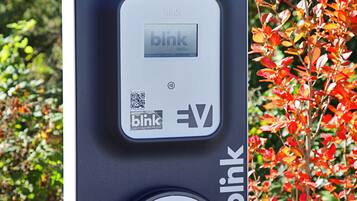 A Blink charging station with a QR code and the Blink logo.