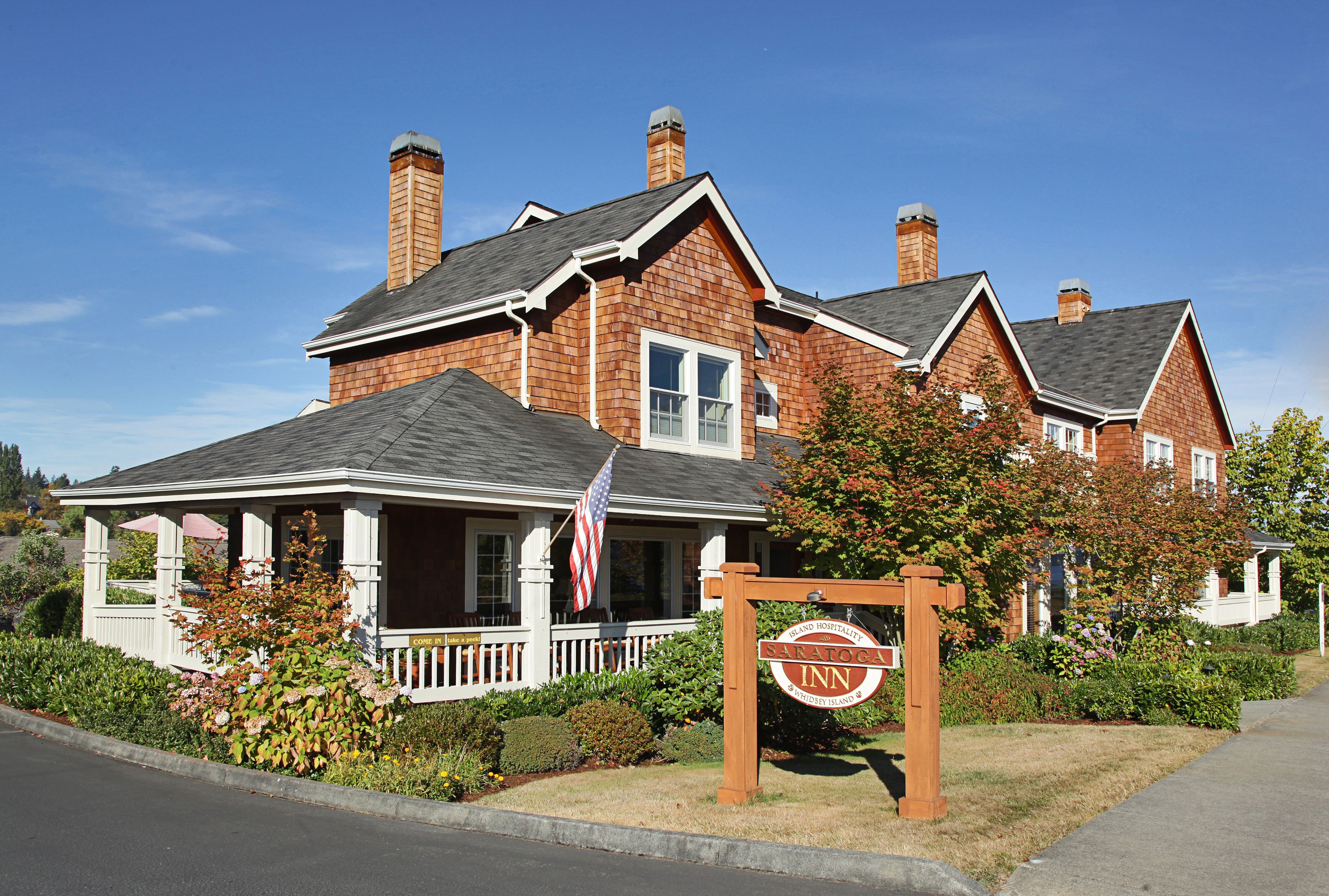 A brick house with a porch, a sign for Sandoval Inn, and an American flag.