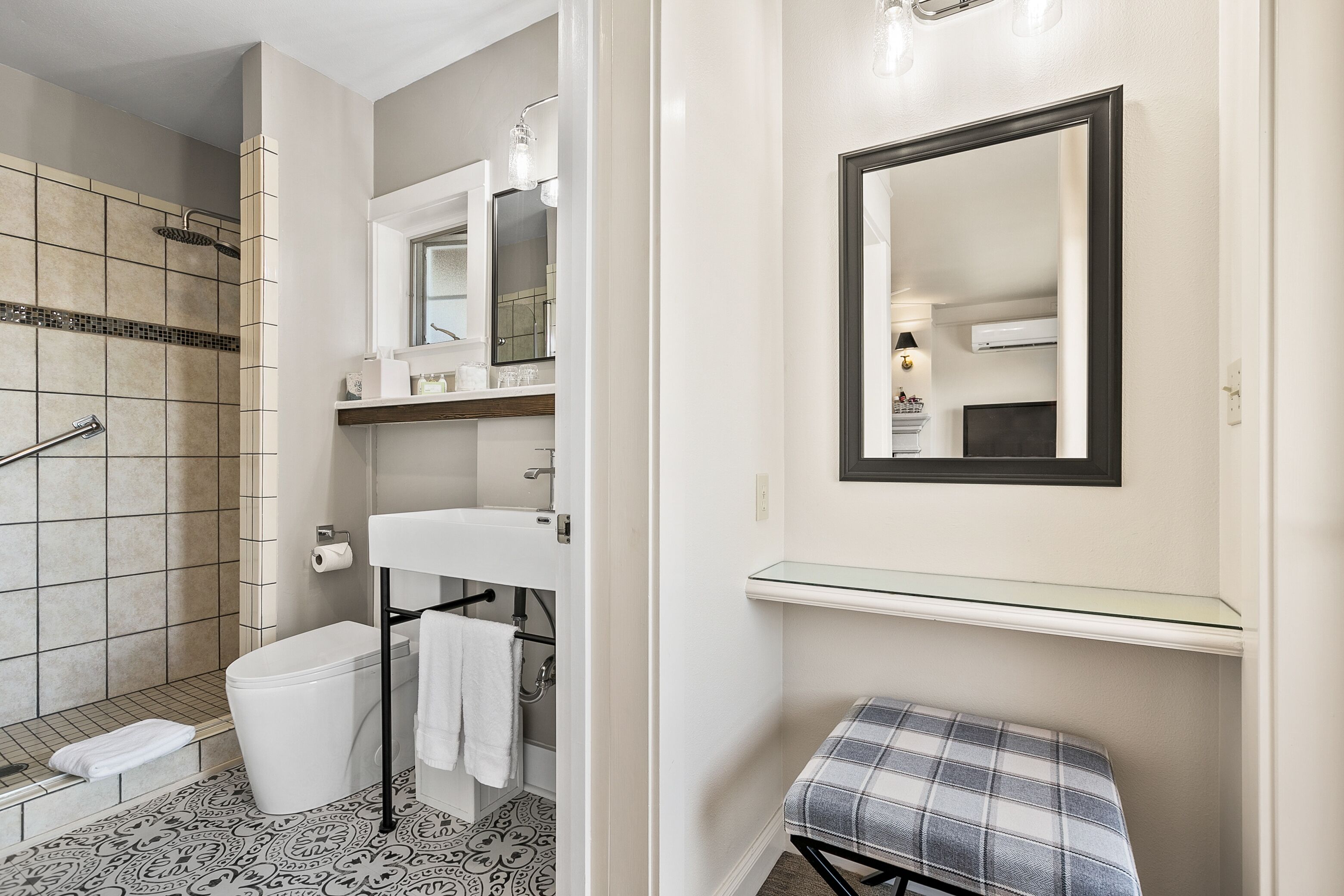 A bathroom with a shower, toilet, sink, and a glass shelf.