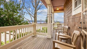 Une terrasse en bois avec des chaises et une vue sur le lac.