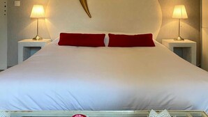 Un dormitorio con una cama grande, dos lámparas de noche y un adorno en la pared.
