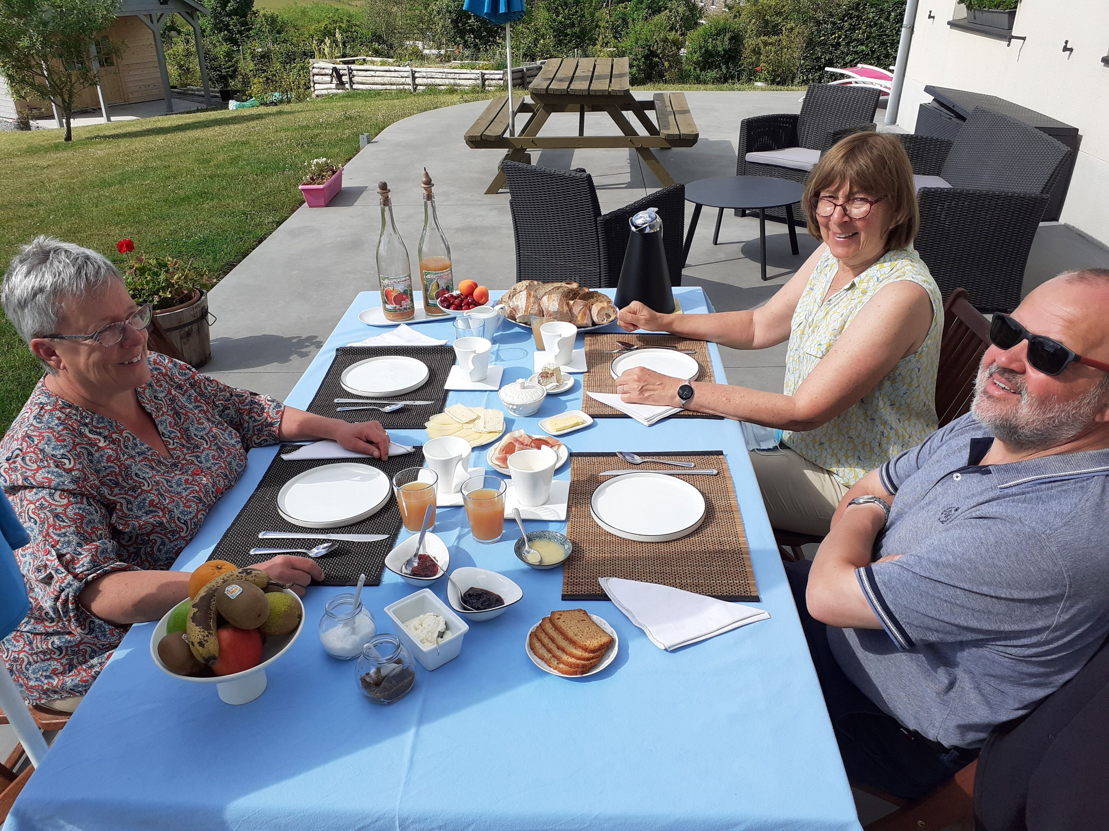 A table set for breakfast with plates, cutlery, and various food items.