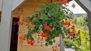 Een houten constructie met een bloemenmand en een bat-logo bord.