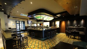 A bar area with stools, a counter, and a patterned floor.